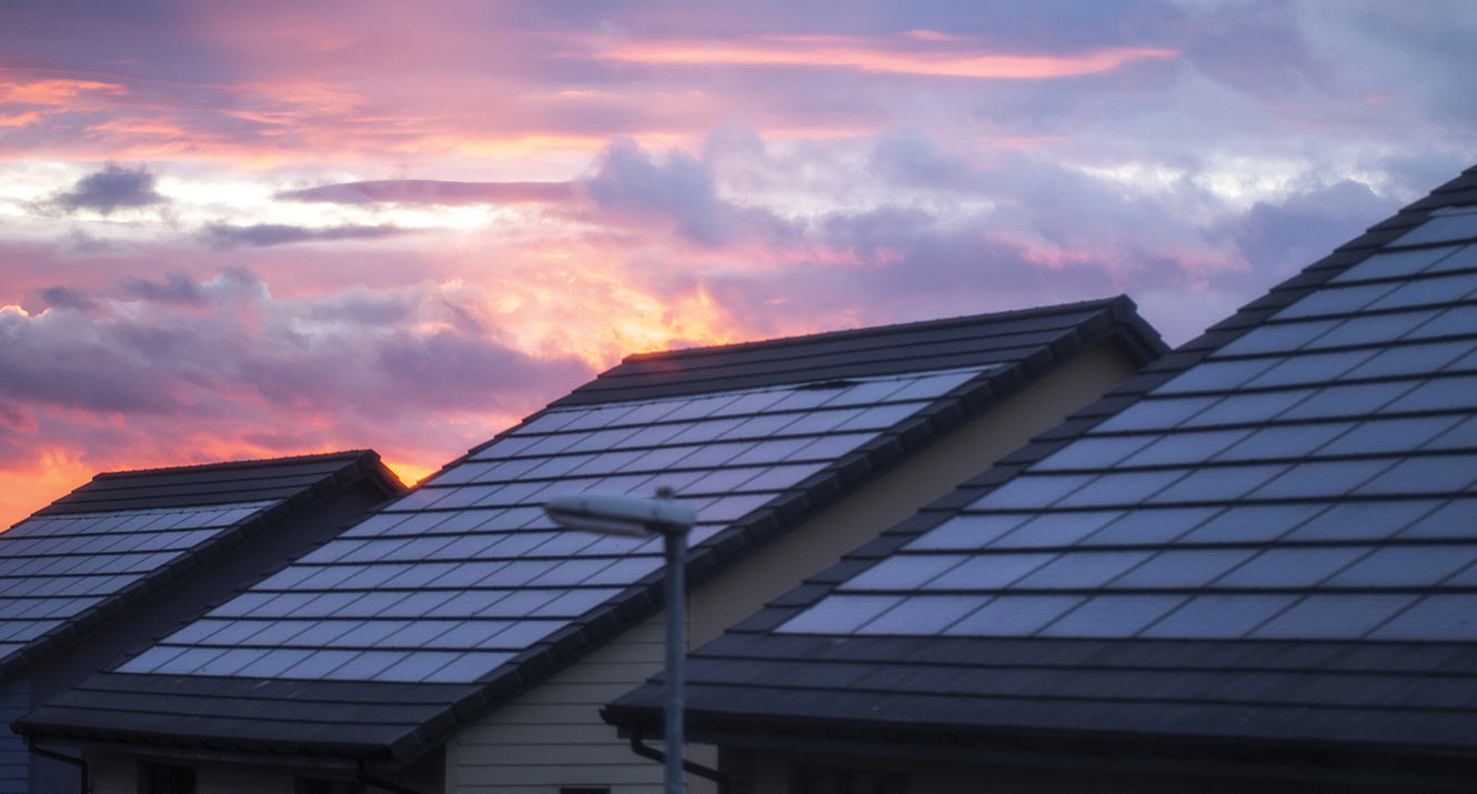 Solar panels on rooftop at sunset.